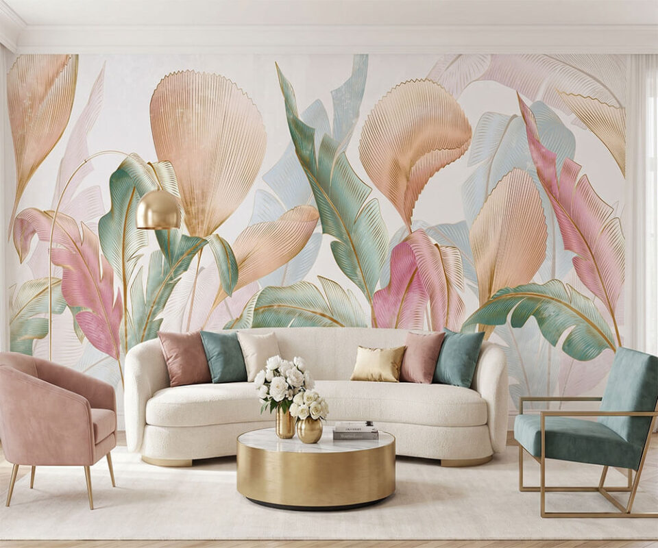 Papier peint panoramique feuilles tropicales pastel posé dans un salon moderne avec canapé blanc et fauteuils roses